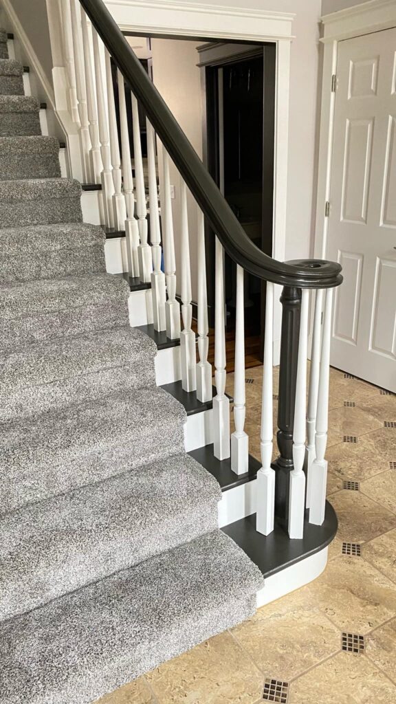 Contemporary staircase with black handrail and white balusters by Franc Painting in Akron, Ohio.