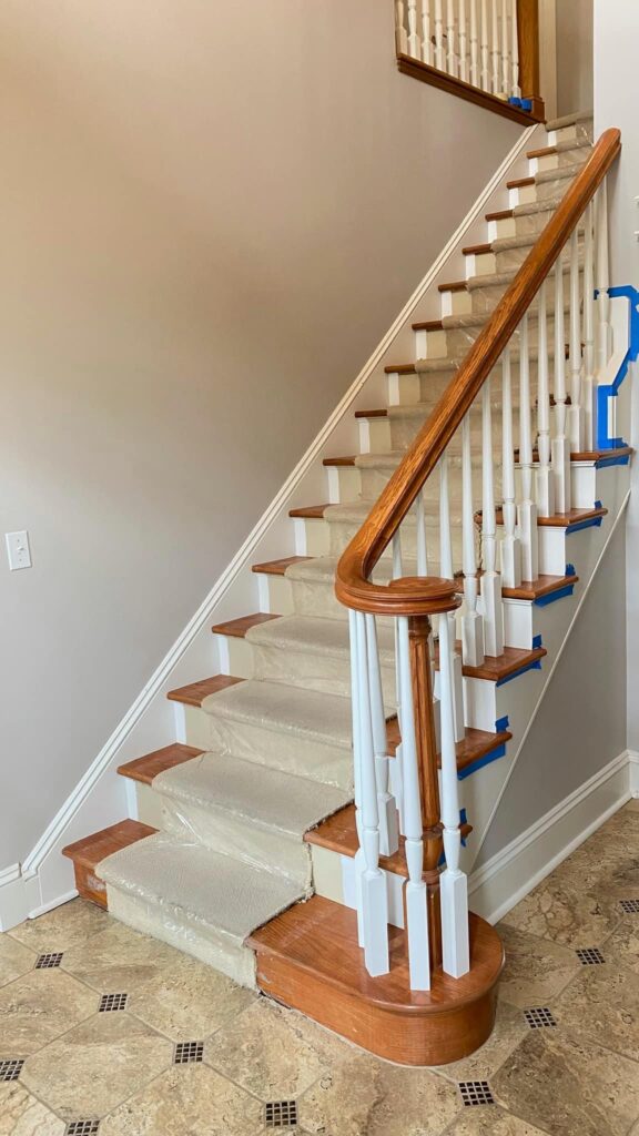 Staircase with white balusters and wood handrail by Franc Painting in Akron, Ohio.