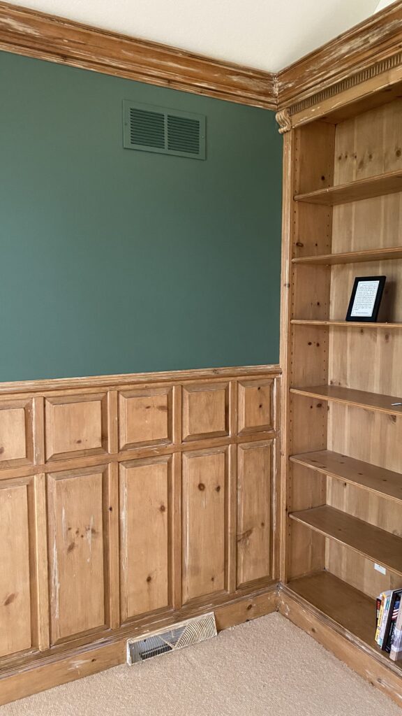 Green accent wall with wood cabinetry and shelves in a living room by Franc Painting in Akron, OH.