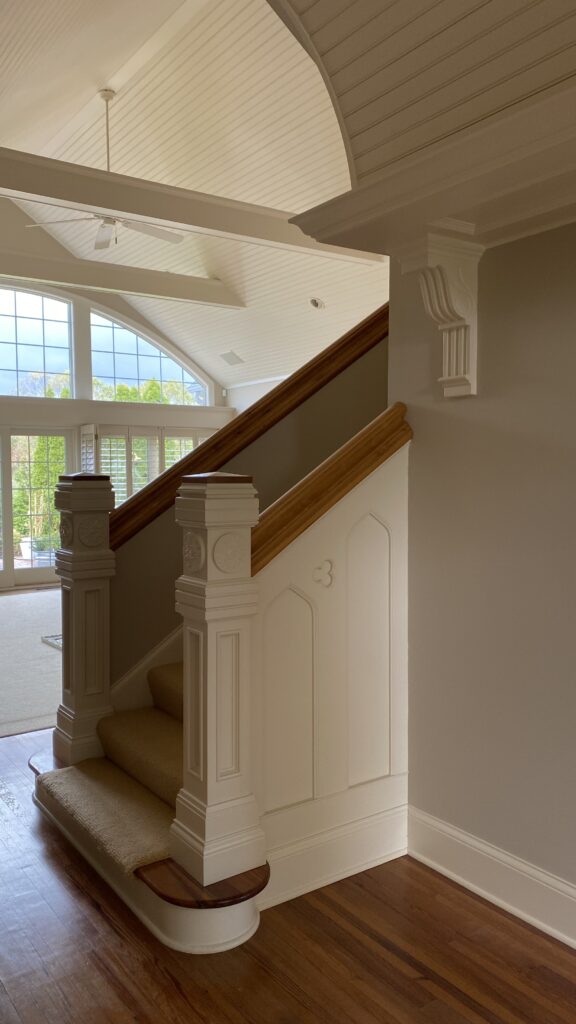 White and wood detailed staircase in a home by Franc Painting.