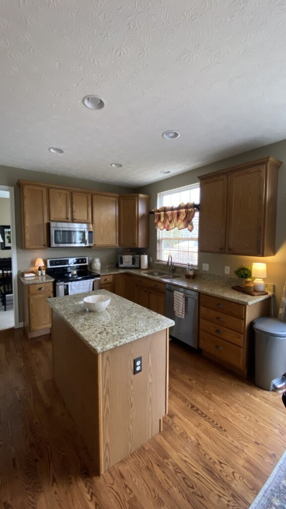 Modern kitchen with wood cabinets, granite countertops, and expertly painted walls in Akron, Ohio.