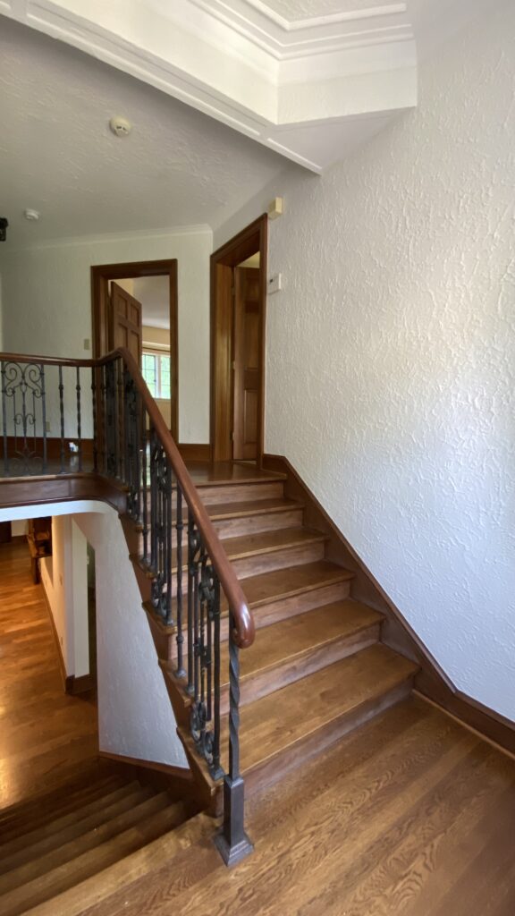 Staircase with wrought iron railing and neutral-painted walls by Franc Painting in Akron, Ohio.
