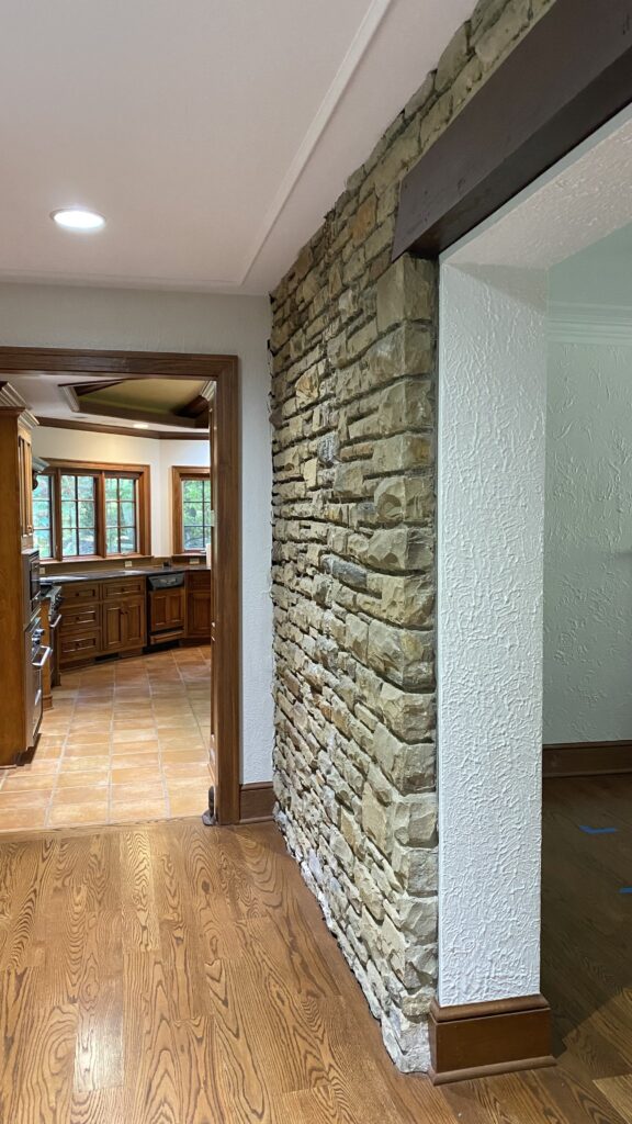 Stone accent wall in Akron home with neutral-painted walls by Franc Painting.